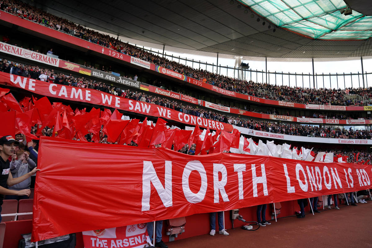 Arsenal fans pictured holding up a banner reading "NORTH LONDON IS RED" during a game against Tottenham in October 2022