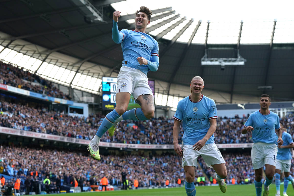 John Stones pictured jumping into the air to celebrate after scoring for Manchester City against Leicester in April 2023