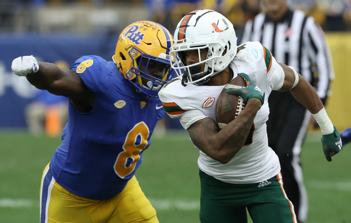 Miami Hurricanes running back Jaylan Knighton (4) runs against Pittsburgh Panthers defensive lineman Calijah Kancey (8) after a catch during the fourth quarter at Heinz Field.