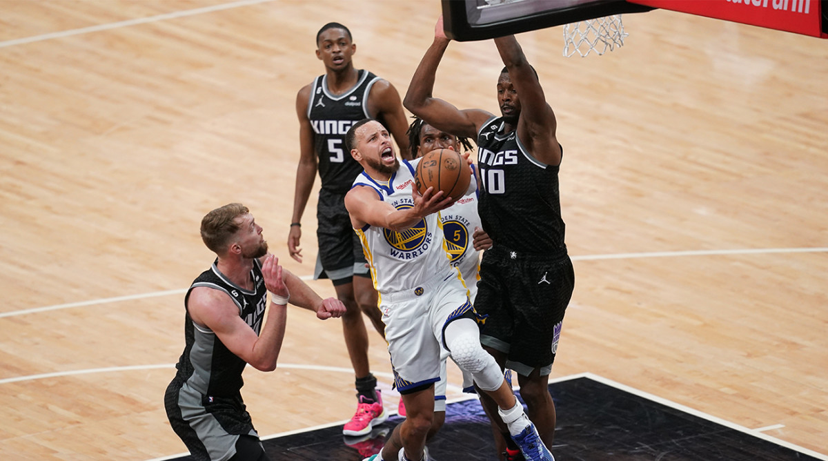 Warriors’ Steph Curry puts up a layup amid a sea of Kings defenders in Game 1 of the NBA playoffs.