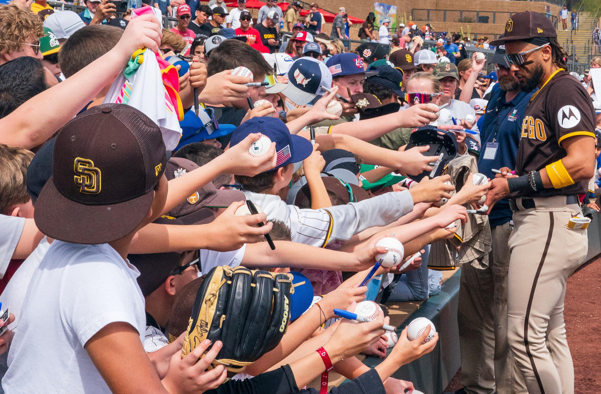 Fans swarm Fernando Tatis for his autograph during a spring training game in Arizona.