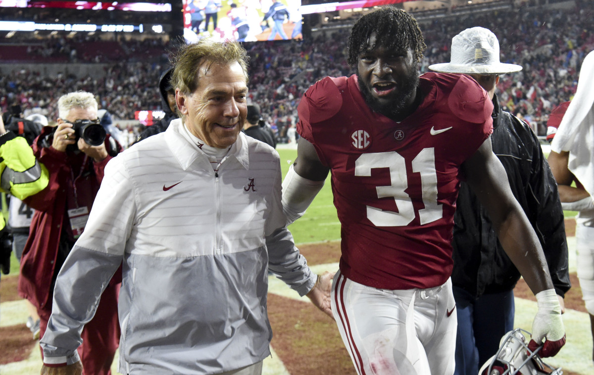 Alabama coach Nick Saban and Will Anderson Jr. walk off the field, smiling side by side in conversation
