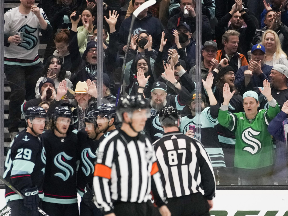 Seattle Kraken fans pound the glass as they celebrate a goal by right wing Jordan Eberle against the Arizona Coyotes.