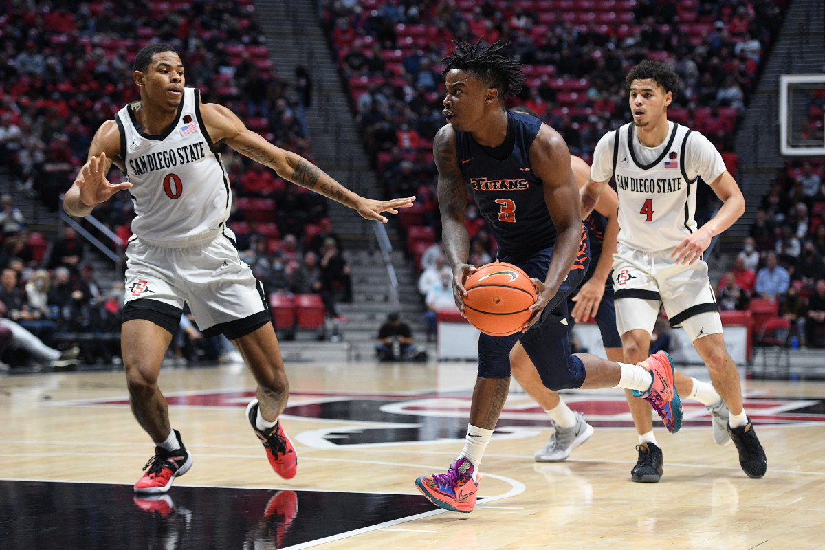 Dec 8, 2021; San Diego, California, USA; Cal State Fullerton Titans guard Latrell Wrightsell Jr. (3) goes to the basket while defended by San Diego State Aztecs forward Keshad Johnson (0) during the second half at Viejas Arena. Mandatory Credit: Orlando Ramirez-USA TODAY Sports