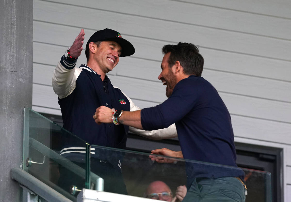 Wrexham AFC co-owners Rob McElhenney (left) and Ryan Reynolds pictured celebrating during their team's win over Boreham Wood in April 2023 that sealed promotion to the English Football League