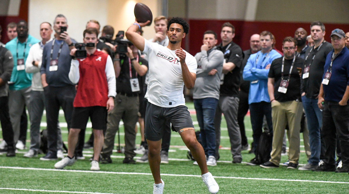 Quarterback Bryce Young throws during Pro Day as coaches stand behind and watch him