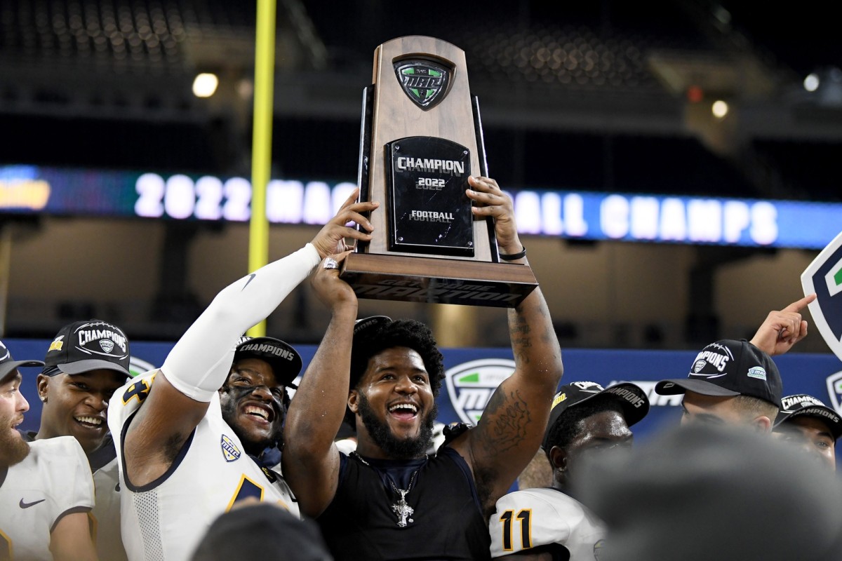 Dec 3, 2022; Detroit, Michigan, USA; Toledo linebacker Jackson Barrow (42) (left) and Desjuan Johnson (right) celebrate with the MAC Championship trophy after beating Ohio University at Ford Field. Mandatory Credit: Lon Horwedel-USA TODAY Sports