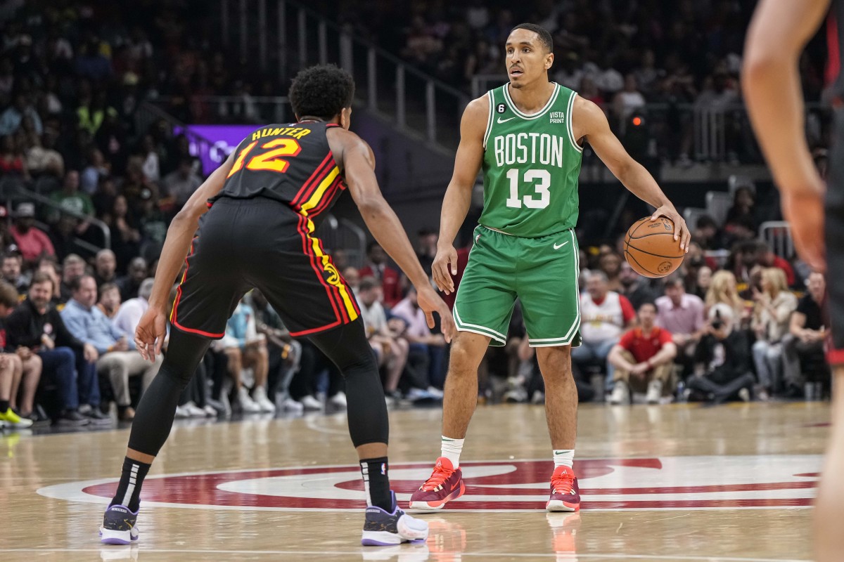Boston Celtics guard Malcolm Brogdon (13) controls the ball in front of Atlanta Hawks forward De'Andre Hunter (12) during the first half during game three of the 2023 NBA playoffs at State Farm Arena.