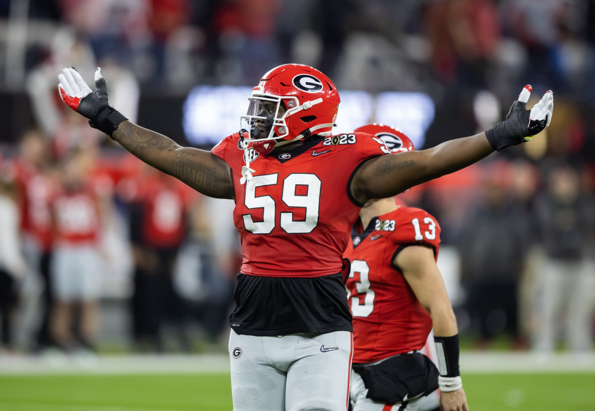 Georgia Bulldogs offensive lineman Broderick Jones holds his hands up and out to the sky