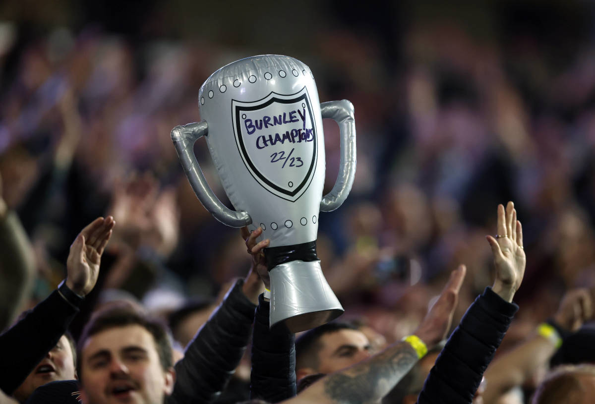 A fan pictured holding up an inflatable trophy at Ewood Park on the night that Burnley were confirmed as champions of the EFL Championship in April 2023
