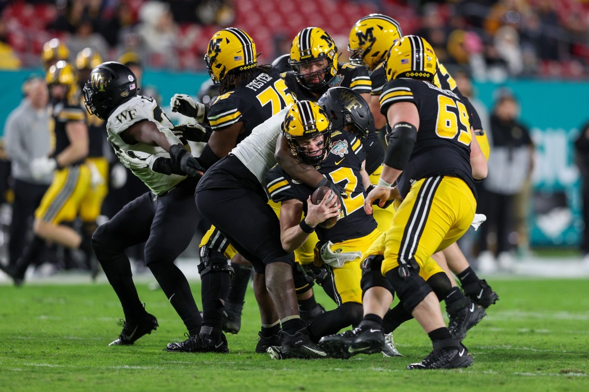 Dec 23, 2022; Tampa, Florida, USA; Missouri Tigers quarterback Brady Cook (12) is sacked by Wake Forest Demon Deacons defensive lineman Kobie Turner (0) in the fourth quarter in the 2022 Gasparilla Bowl at Raymond James Stadium. Mandatory Credit: Nathan Ray Seebeck-USA TODAY Sports