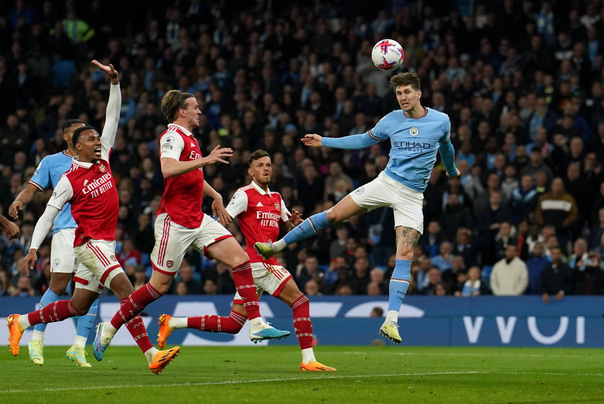 John Stones pictured (right) heading the ball to score for Manchester City against Arsenal in April 2023
