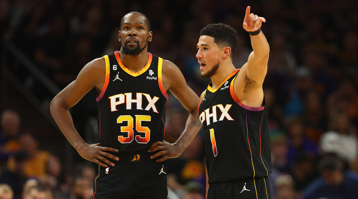 Suns’ Kevin Durant, Devin Booker strategize during NBA playoff game.
