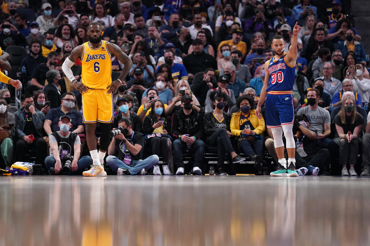 LeBron and Steph Curry wait along the sidelines during a timeout.