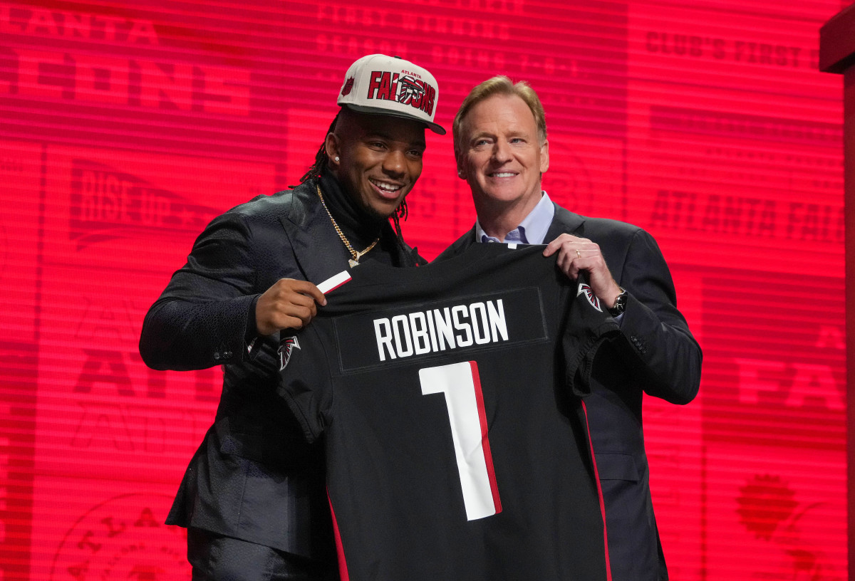 Texas running back Bijan Robinson with NFL commissioner Roger Goodell holding a Falcons jersey with his last name on the back