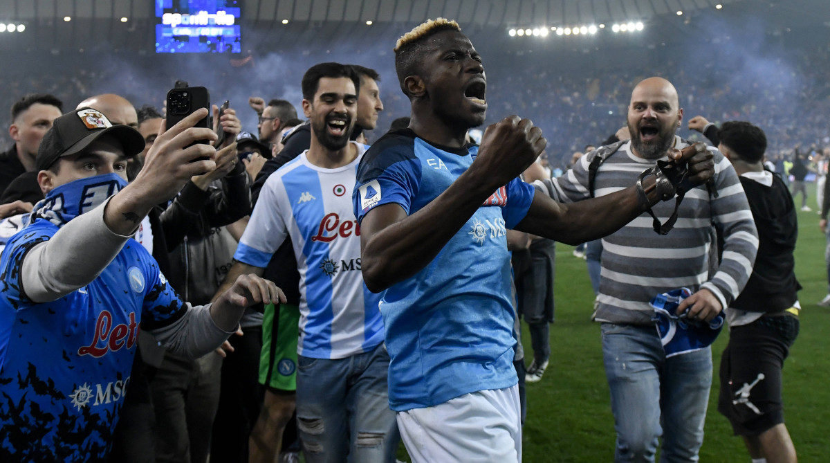 Napoli striker Victor Osimhen celebrates with fans after winning the league title.