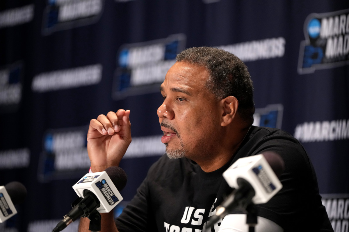 head coach Ed Cooley talks into a microphone during a March Madness press conference