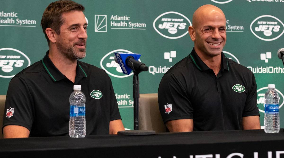Jets quarterback Aaron Rodgers and head coach Robert Saleh smile while attending a press conference with the media.