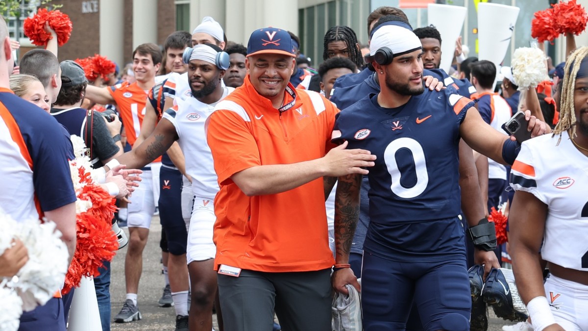 Tony Elliott embraces Antonio Clary during the Wahoo Walk before the Virginia football spring game at Scott Stadium.