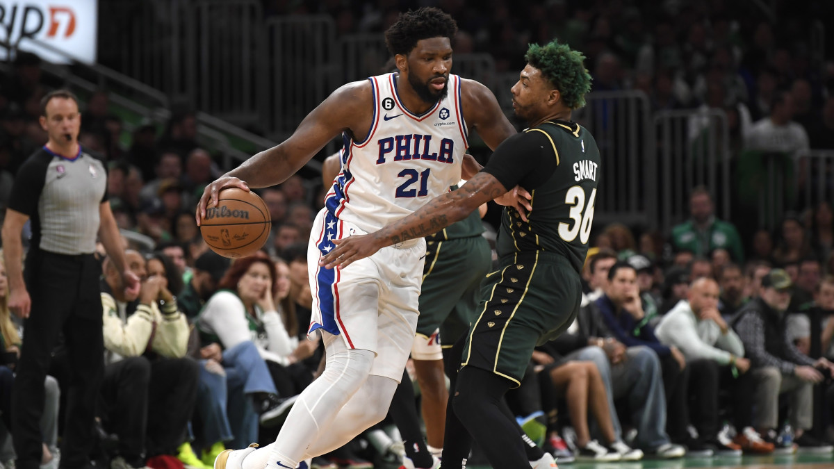 Philadelphia 76ers center Joel Embiid controls the ball while Boston Celtics guard Marcus Smart defends.