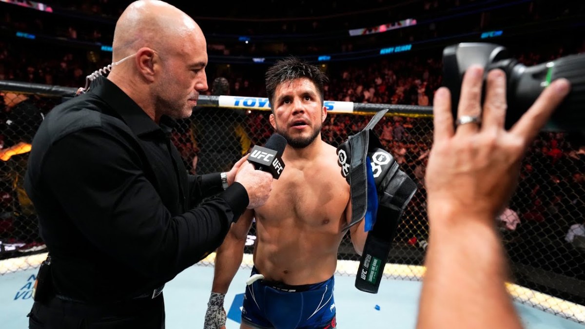 Henry Cejudo takes off his gloves after losing to Aljamain Sterling at UFC 288