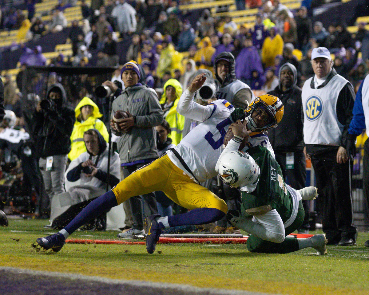 Nov 19, 2022; Baton Rouge, Louisiana, USA; LSU Tigers quarterback Jayden Daniels (5) is tackled out of bounds by UAB Blazers safety Jaylen Key (1) and flagged for a course collar tackle during the second half at Tiger Stadium.