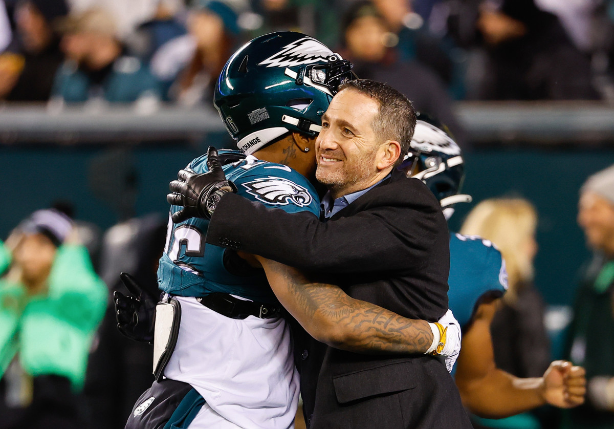 Howie Roseman hugs a player on the Eagles sideline