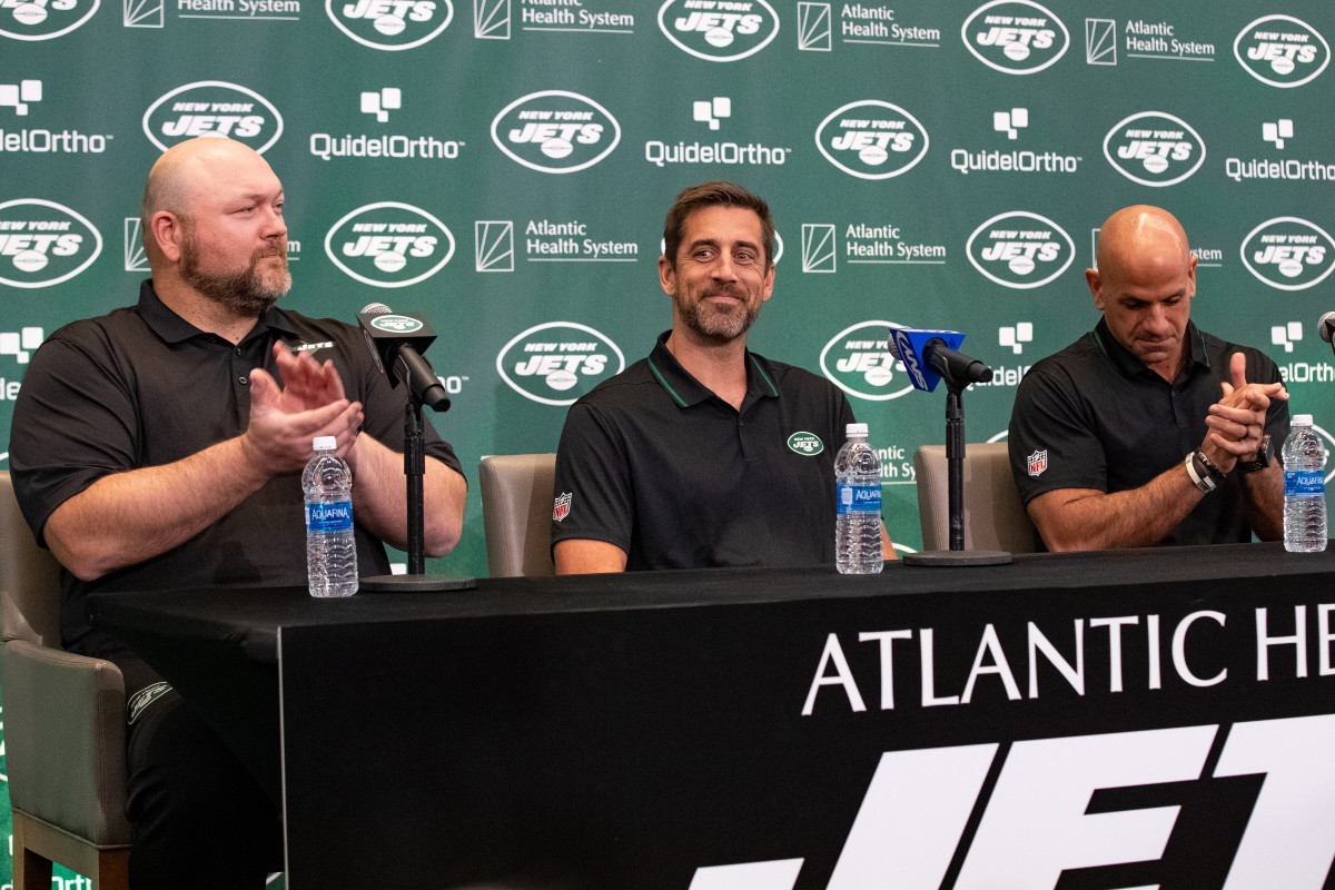 Jets' general manager Joe Douglas (far left) claps during Aaron Rodgers' introductory press conference