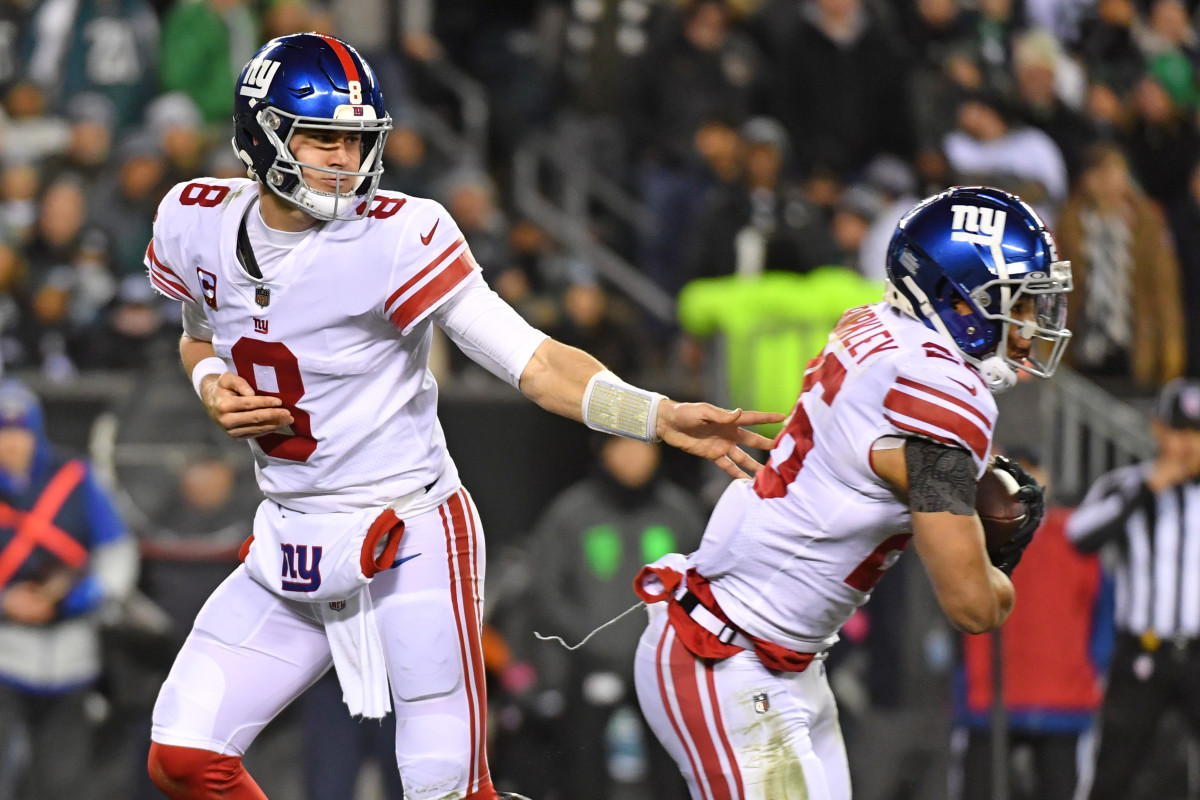 New York Giants quarterback Daniel Jones hands the ball to running back Saquon Barkley