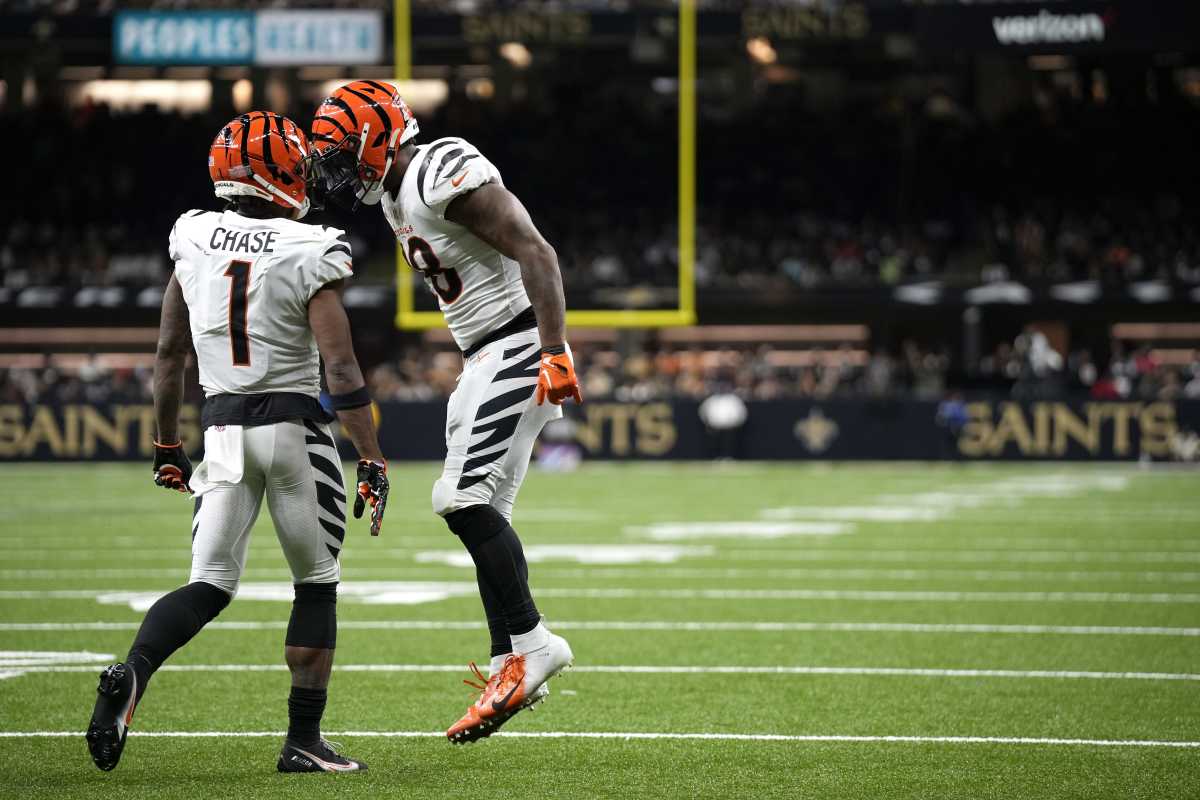 Cincinnati Bengals running back Joe Mixon and teammate Ja'Marr Chase jump and put their helmets together in celebration