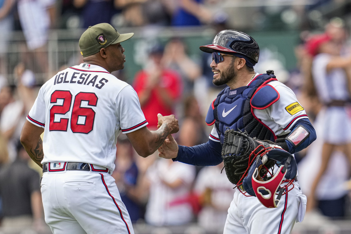 May 21, 2023; Cumberland, Georgia, USA; Atlanta Braves relief pitcher Raisel Iglesias (26) reacts with catcher Travis d'Arnaud (16) after the Braves defeated the Seattle Mariners at Truist Park.