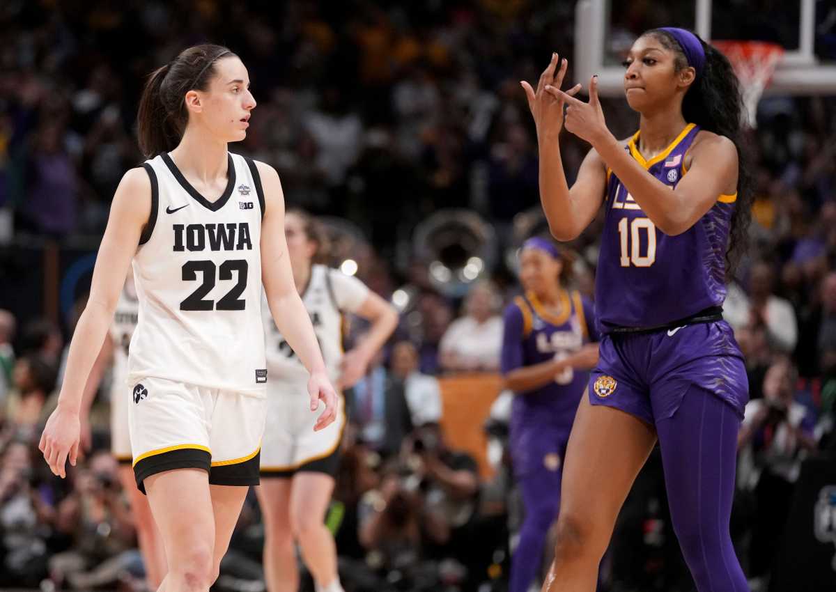 LSU forward Angel Reese (10) shows Iowa guard Caitlin Clark (22) her ring finger