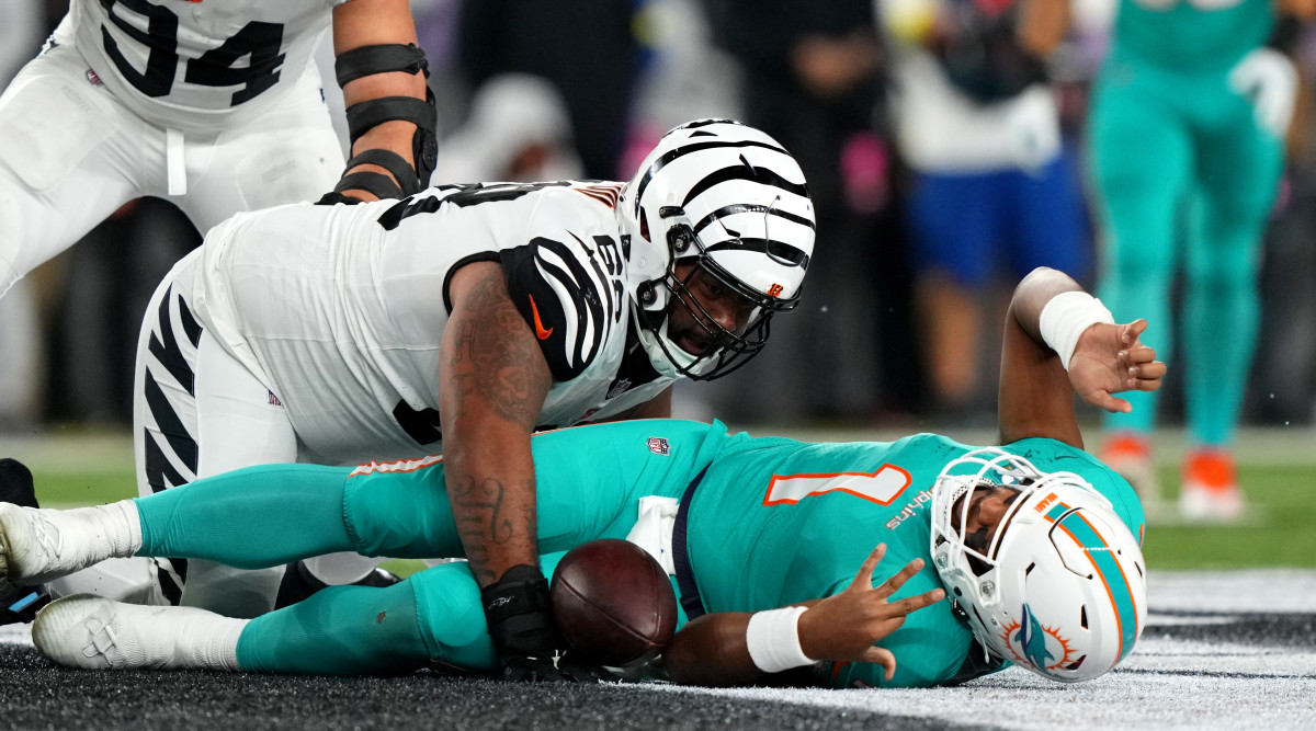 Dolphins quarterback Tua Tagovailoa lies on the ground after being sacked by Bengals defensive tackle Josh Tupou. Tagovailoa sustained a concussion on the play.