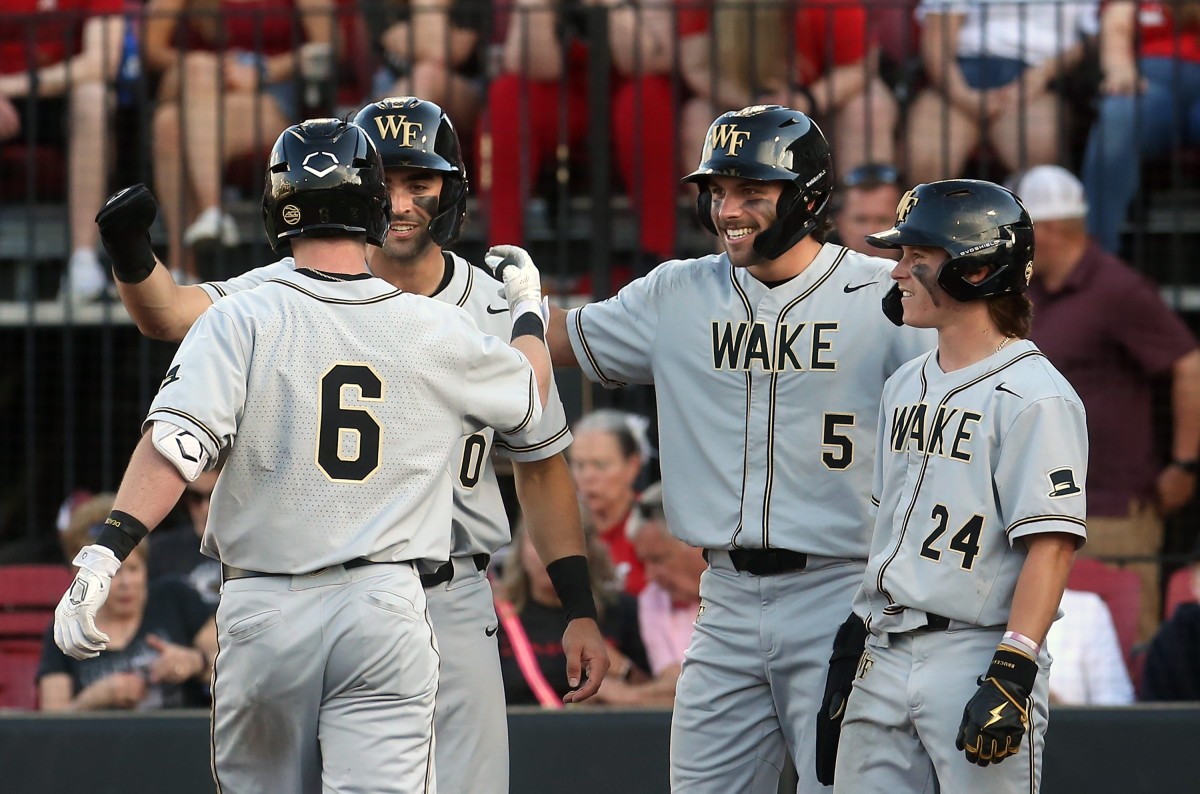 Wake Forest s Justin Johnson celebrates hitting a grand slam against Louisville with teammates Lucas Costello, Pierce Bennett and Tommy Hawke.April 14, 2023