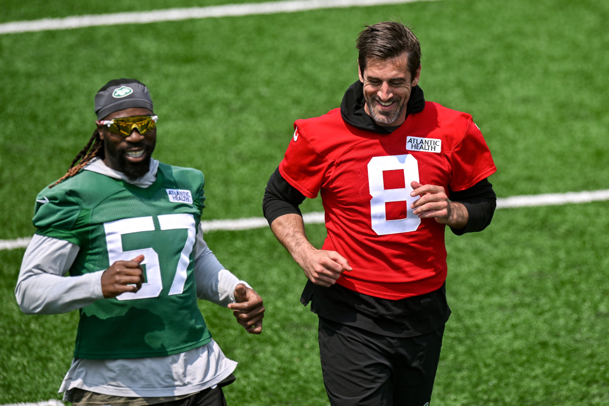 Aaron Rodgers jogs by CJ Mosley at Jets' OTAs