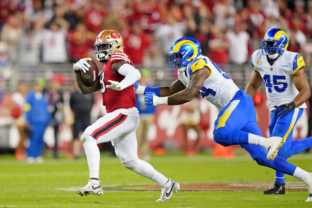 San Francisco 49ers wide receiver Deebo Samuel runs with the ball as linebacker Leonard Floyd lunges to try to tackle him