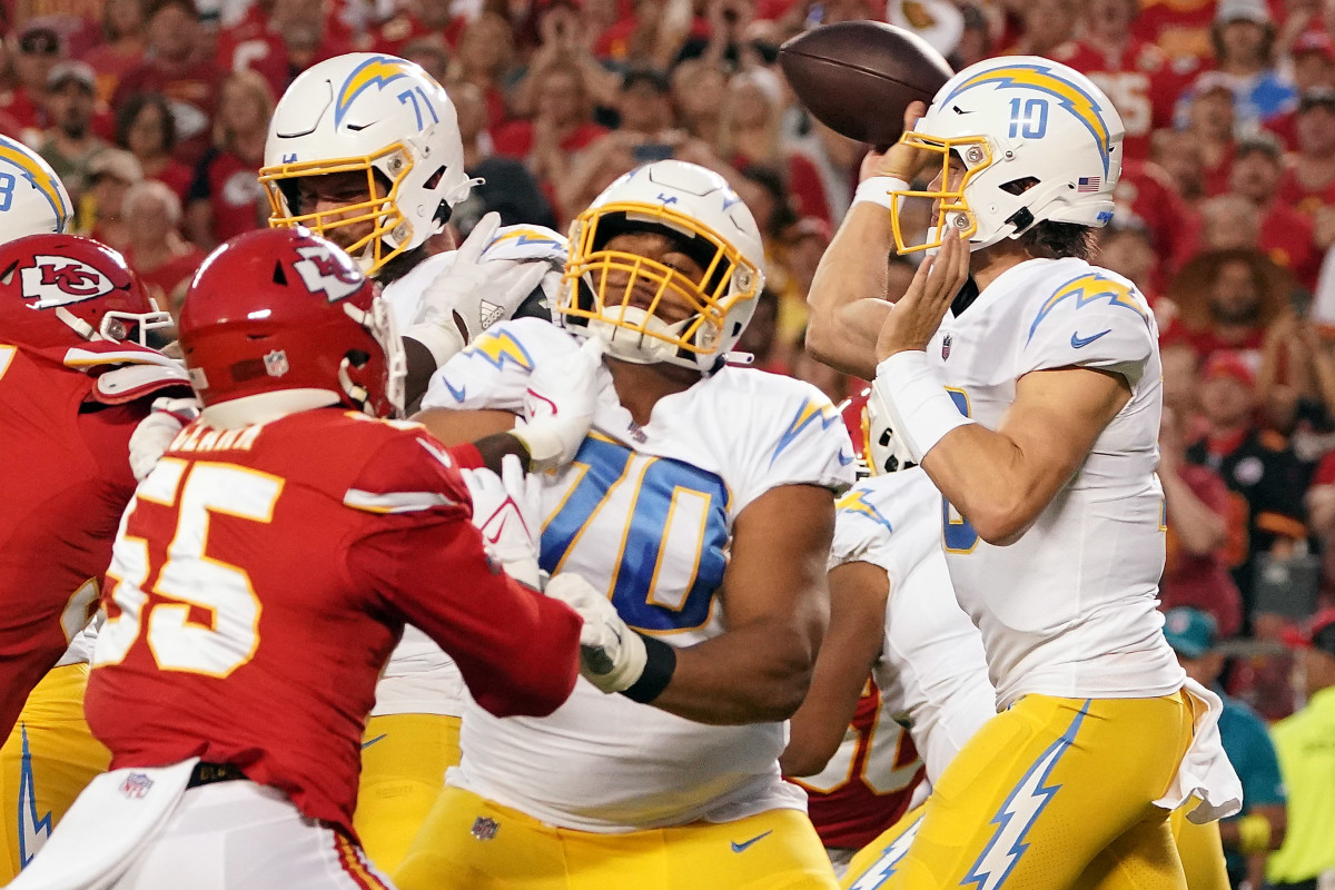 Rashawn Slater pushes up against a Chiefs defensive lineman as Justin Herbert throws the ball next to him