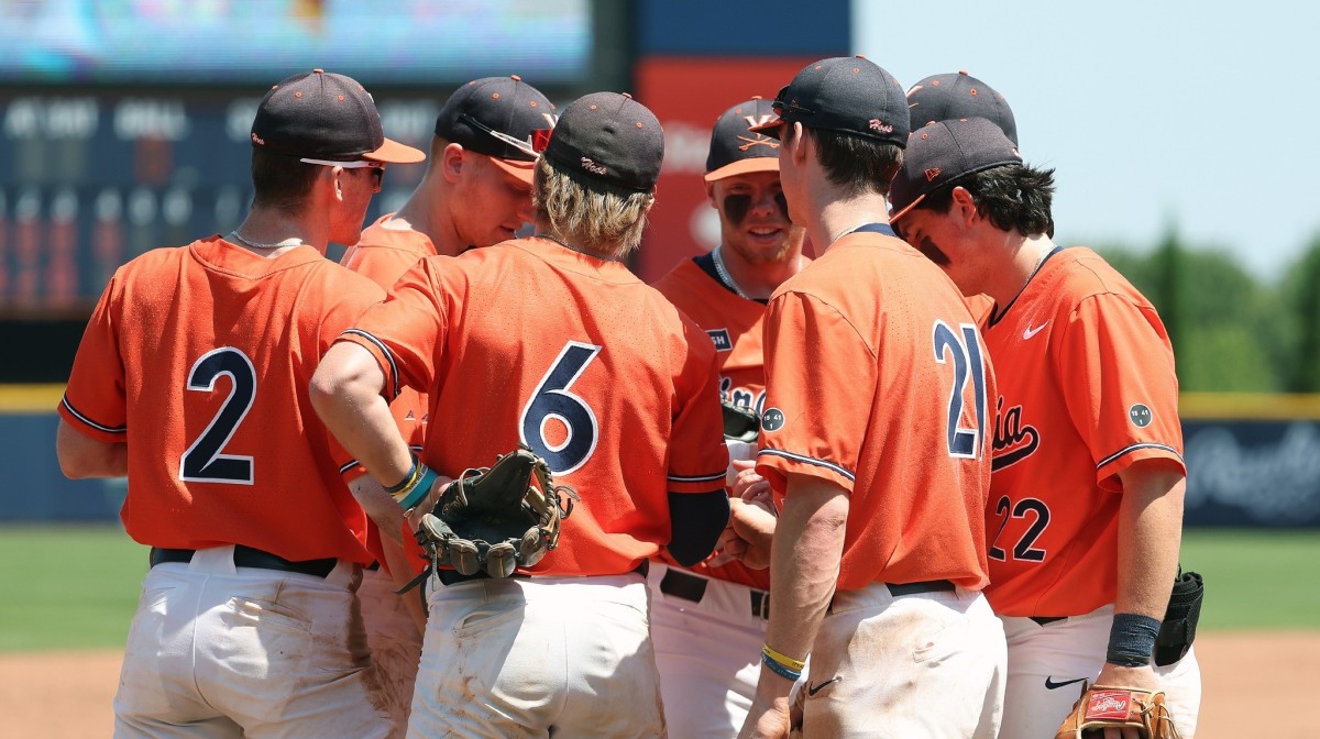 The Virginia baseball team huddles on third base during the game against Louisville at Disharoon Park.