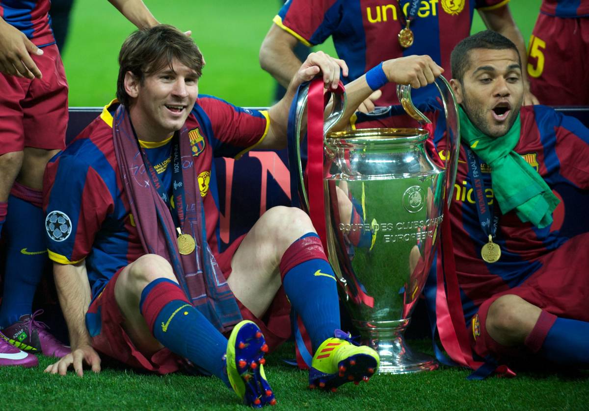 Lionel Messi (left) and Dani Alves pictured holding the UEFA Champions League trophy after winning it with Barcelona in May 2011