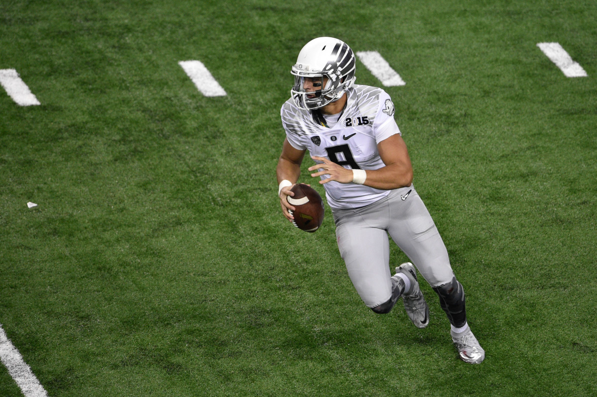 Jan 12, 2015; Arlington, TX, USA; Oregon Ducks quarterback Marcus Mariota (8) runs with the ball against the Ohio State Buckeyes during the game at AT&T Stadium. The Buckeyes defeated the Ducks 42-20. Mandatory Credit: Jerome Miron-USA TODAY Sports