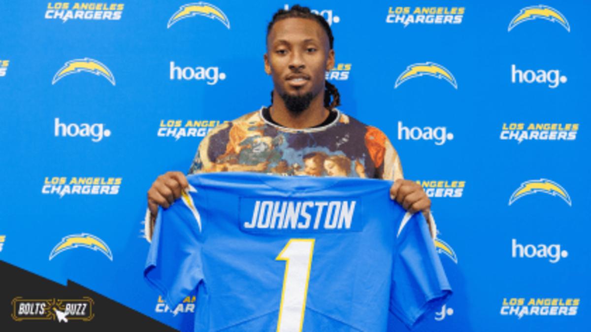 Quentin Johnston holds up his Chargers' jersey at his introductory press conference.