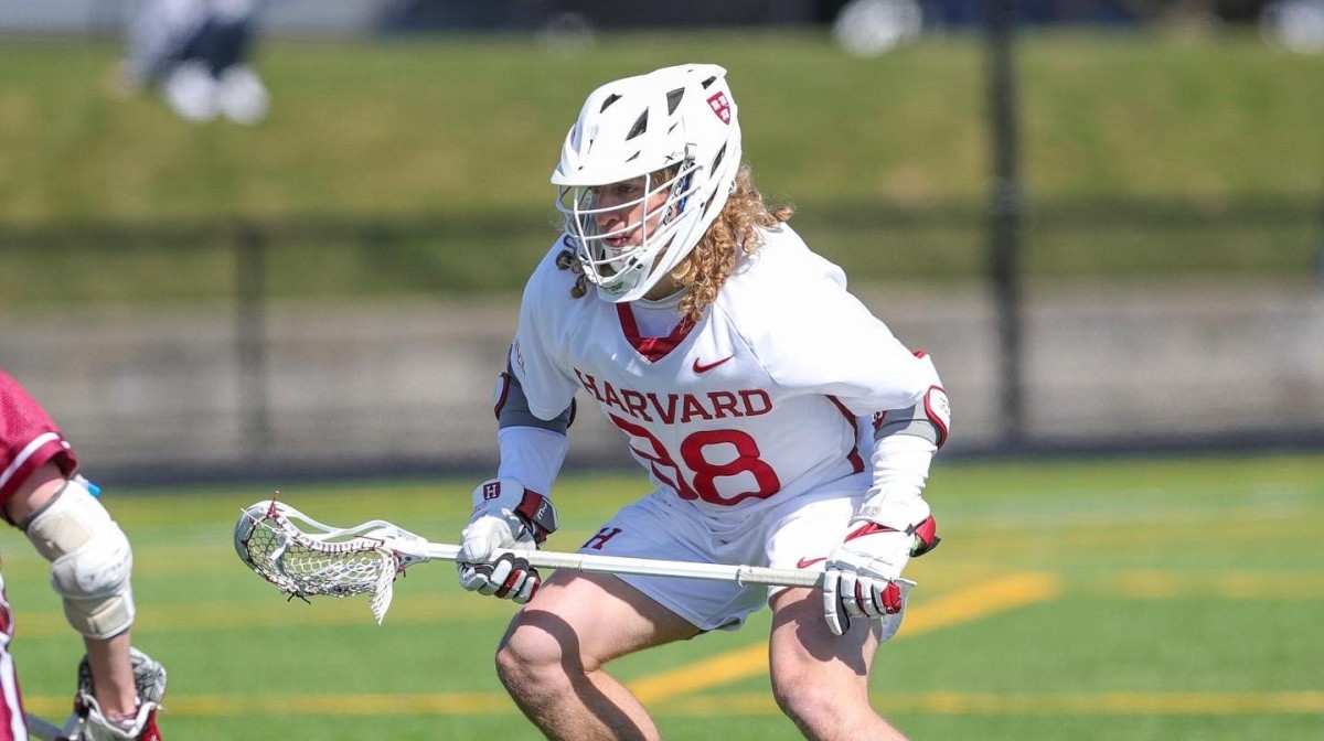 Senior defensive midfielder Chase Yager defends the ball during a Harvard men's lacrosse game.