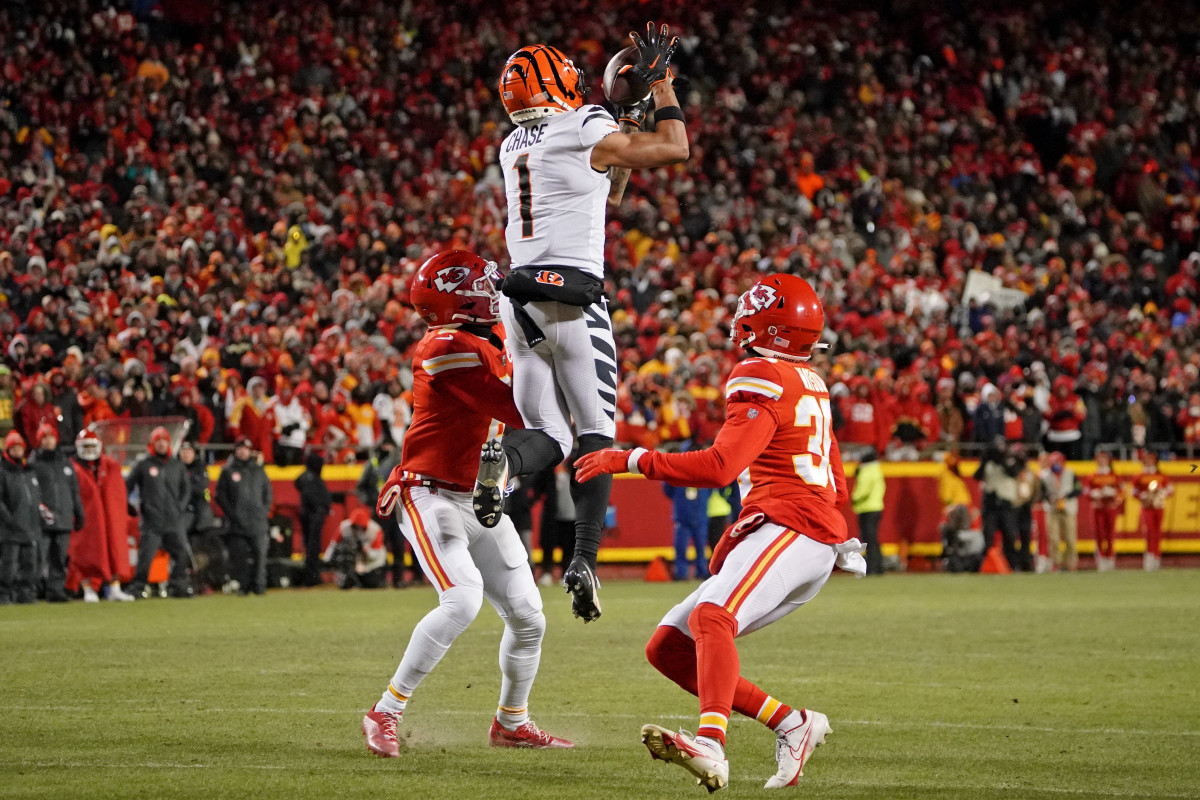 Cincinnati Bengals wide receiver Ja'Marr Chase jumps in the air to catch the football as two Chiefs defenders stand below him