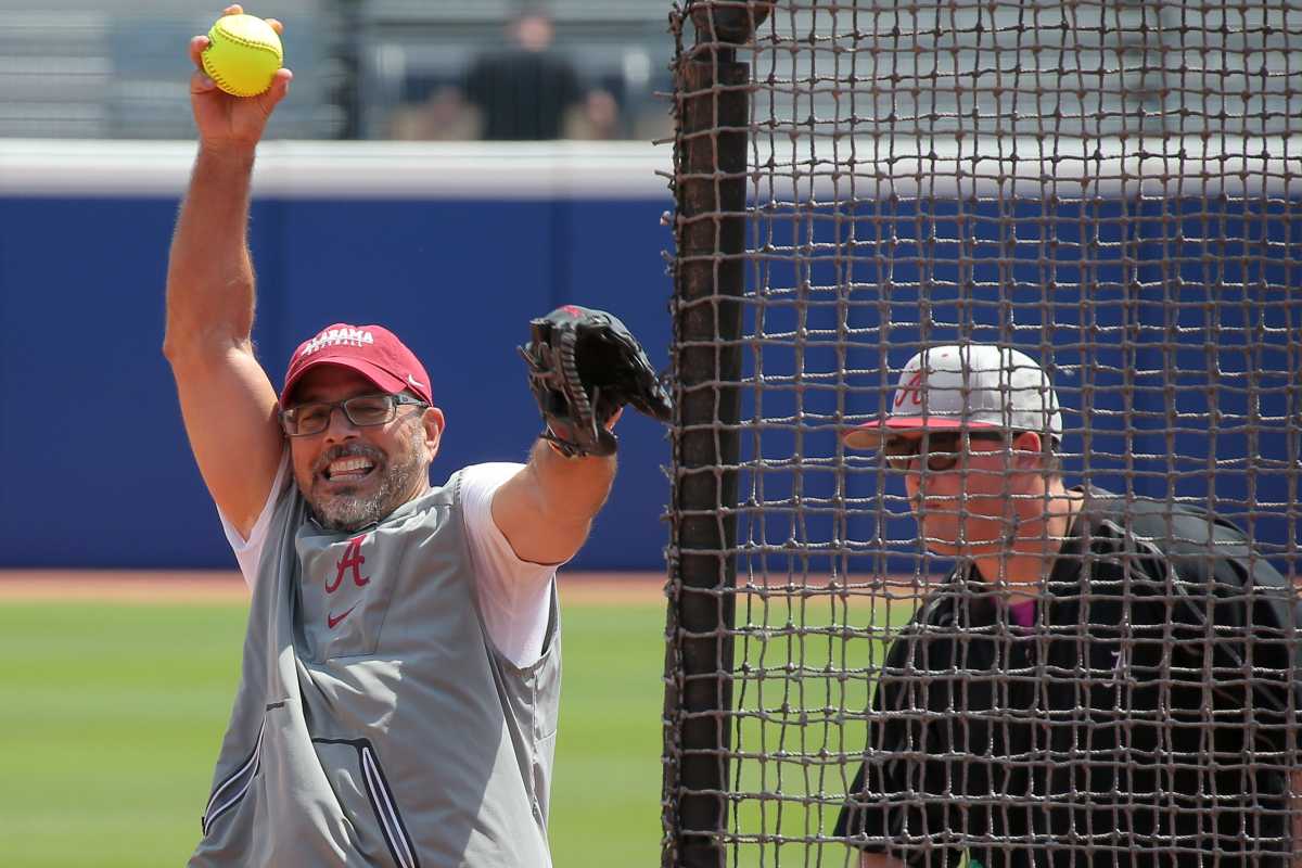Alabama coach Patrick Murphy pitches during a practice for the Women's College World Series at USA Softball Hall of Fame Stadium in Oklahoma City, Wednesday, May 31, 2023.