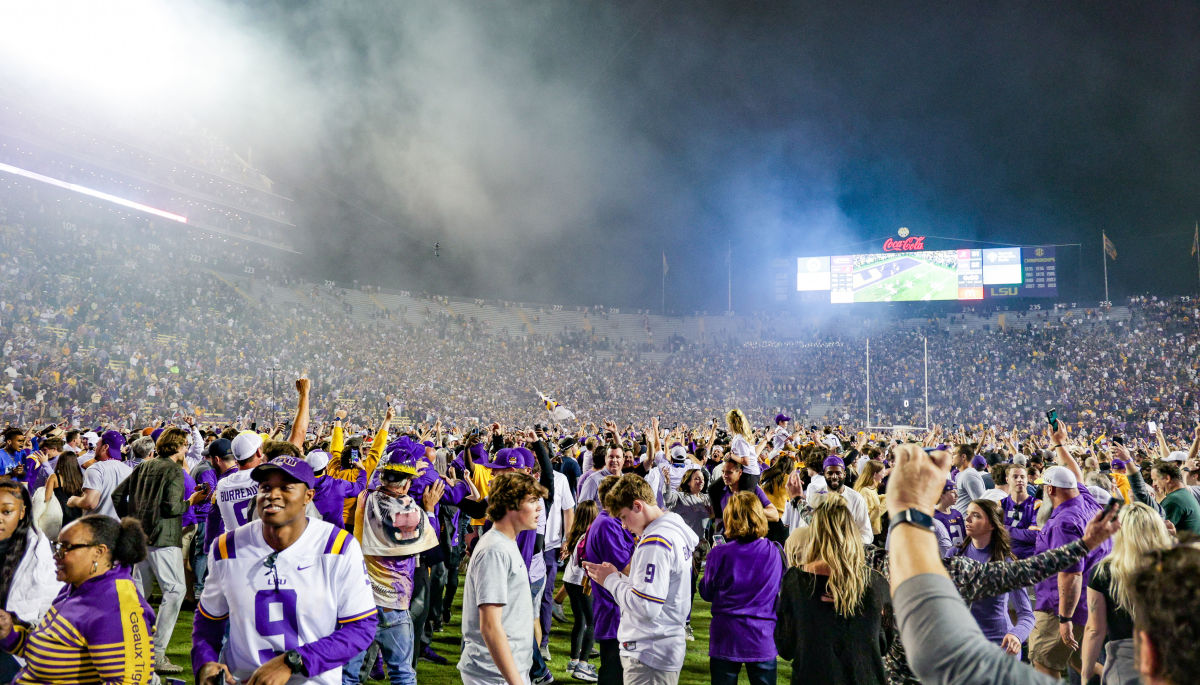 a football field filled with LSU students and fans, with fog in the air above it