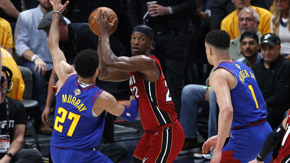 Miami Heat forward Jimmy Butler controls the ball while defended by Denver Nuggets guard Jamal Murray.