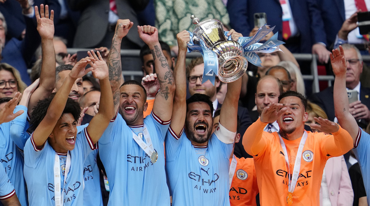 Manchester City's Ilkay Gundogan raises the trophy after his team won the English FA Cup.
