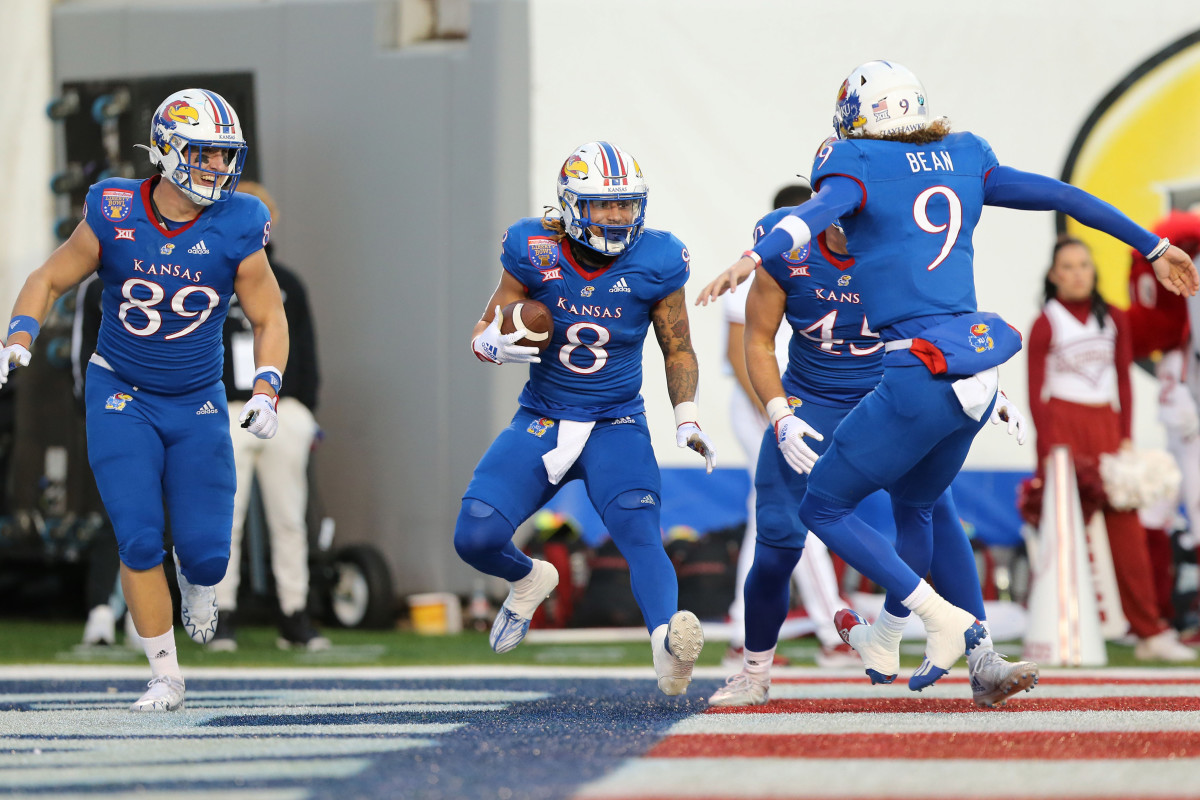 Dec 28, 2022; Memphis, TN, USA; Kansas Jayhawks running back Ky Thomas (8) celebrates with tight end Mason Fairchild (89) and quarterback Jason Bean (9) after catching a pass for a touchdown against the Arkansas Razorbacks in the first quarter in the 2022 Liberty Bowl at Liberty Bowl Memorial Stadium.