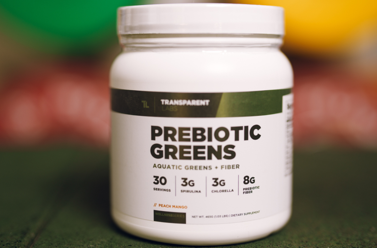 A white and green container of Transparent Labs Prebiotic Greens powder supplement