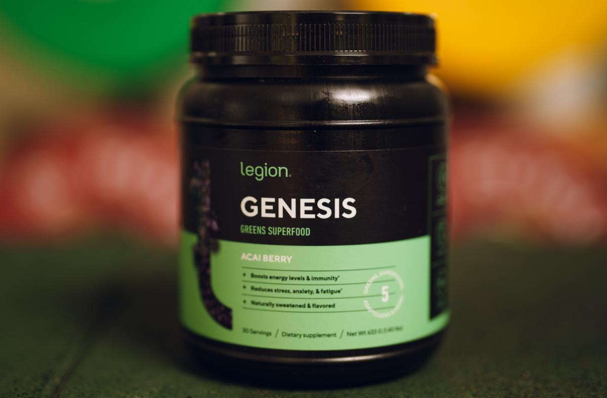 A black and green container of Legion Genesis Greens Superfood powder